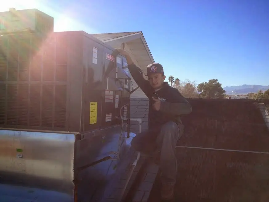 HVAC technician performing Air Duct Cleaning on a rooftop unit in Greenwich